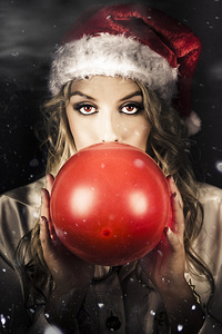 Young Christmas Girl Blowing Up Party Balloon