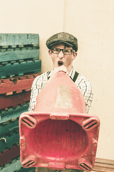 Young handsome man sounding out megaphone call by Jorgo