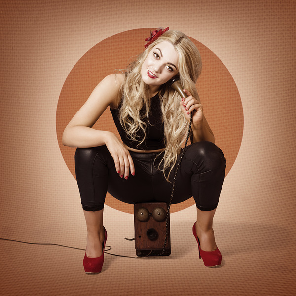 Happy pin up girl talking on retro box telephone by Jorgo