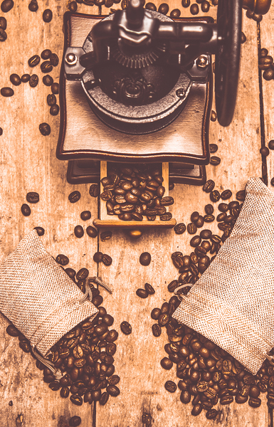 Vintage grinder with sacks of coffee beans by Jorgo