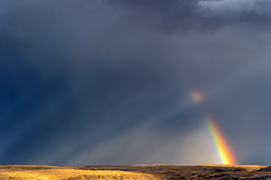 Strong rainbow with diagonal rain clouds
