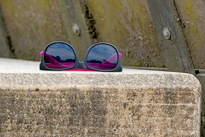 Abandoned sunglasses on concrete ledge