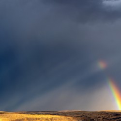Strong rainbow with diagonal rain clouds