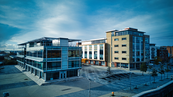 Modern office buildings with glass facades under cloudy sky empty urban business district in Hull England. by Vasile Jechiu