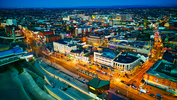Aerial night view of a vibrant cityscape with illuminated streets and buildings showcasing urban life and architecture in Backpool England. by Vasile Jechiu