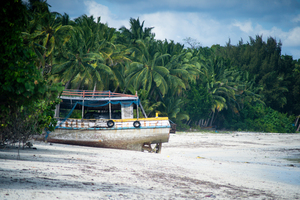 Fishing ship boat stranded on white sand beach