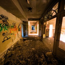 Decaying Hallway With Grafiti In Abandoned Luxurious Hotel