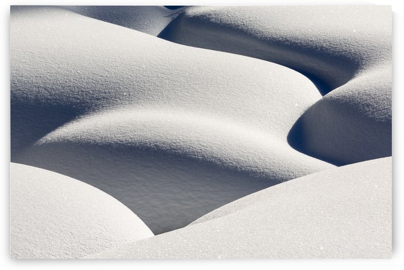 Artistic montage of snow contouring a creek bed with graphic designs of curving highlights and shadows; Lake Louise, Alberta, Canada by PacificStock