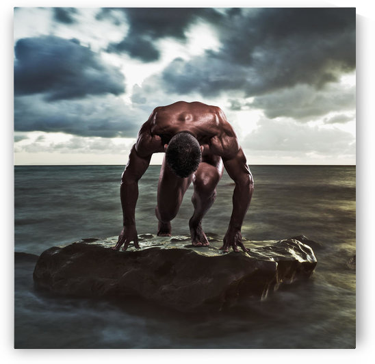 A muscular man in the starting position on a wet rock in the water;Tarifa cadiz andalusia spain by PacificStock