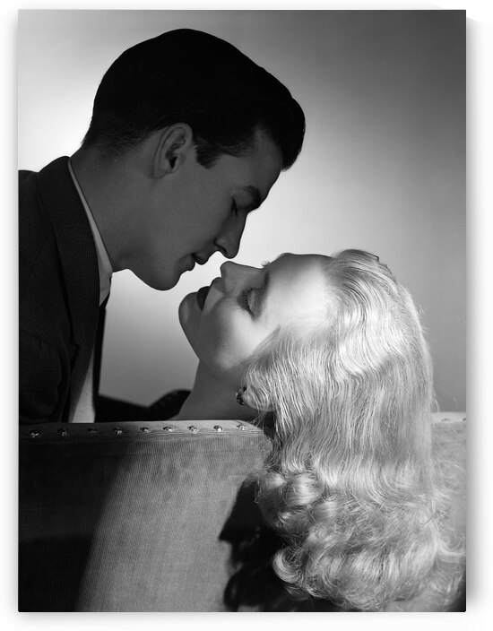 1950s COUPLE EMBRACING ON SOFA ABOUT TO KISS 178698 by Panoramic Images