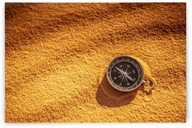 metal compass on sand by Gualtiero Boffi