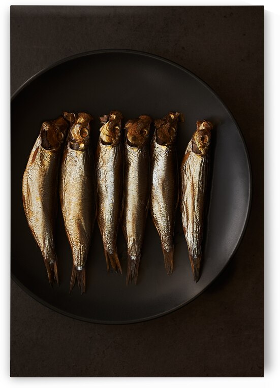 Small smoked fish on black plate by Kata Endrodi Photography