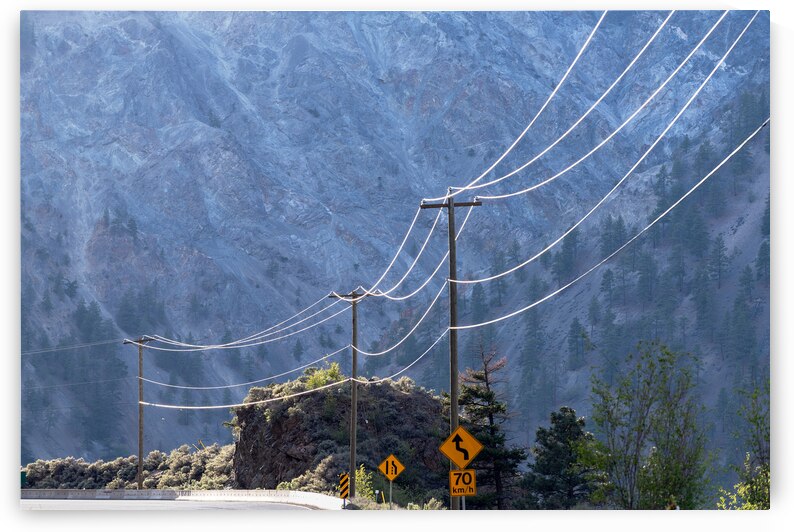 Power lines along the road glistening in the sun by David Reinhold