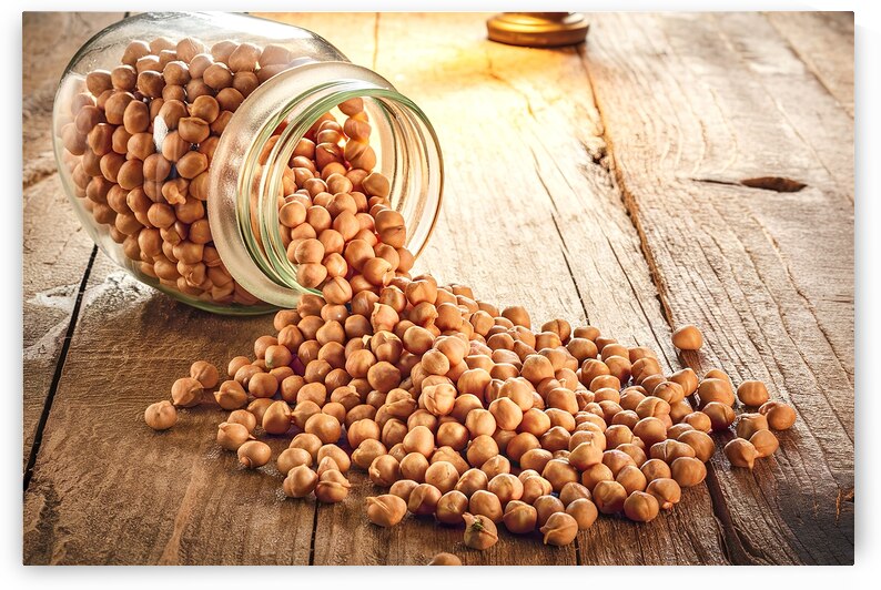 A glass jar filled with chickpeas which is tipped by IonelGherman
