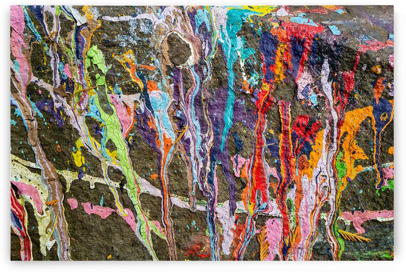 Many colors of paint spilled on a rock by David Reinhold