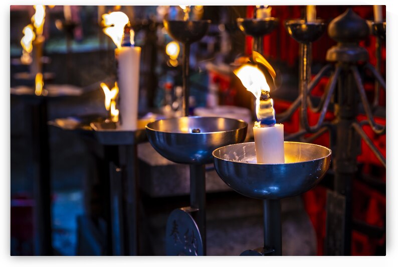 Many candles burning in a temple at night by Gualtiero Boffi