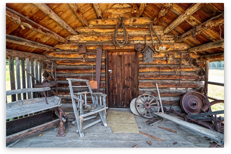 The porch and front entrance to a rustic log cabin by David Reinhold