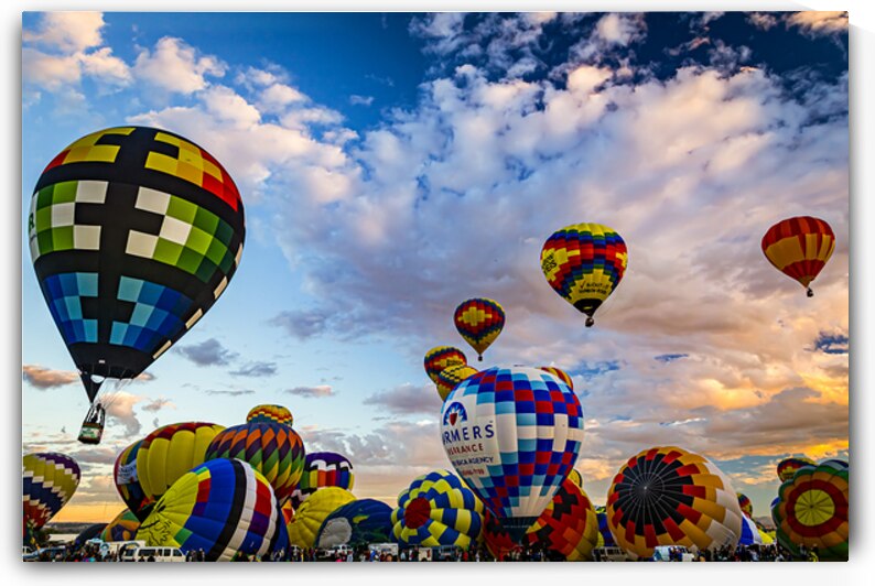 Vibrant hot air balloons filling the sky during a festival at sunrise by Gestalt Imagery