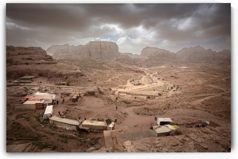 Souvenir stalls dot the rocky landscape of petra jordan under  by Gualtiero Boffi
