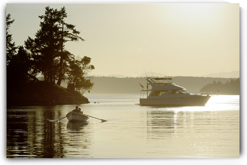 Couple in a dinghy rowing in front of a pleasure motorboat by Kevin Oke