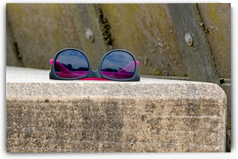 Abandoned sunglasses on concrete ledge by Lisa von Biela