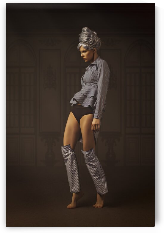 Young woman with grey hair hair wearing a striped shirt and shirt sleeves as leg warmers standing on her toes in an empty dark ballroom by Artmood Visualz