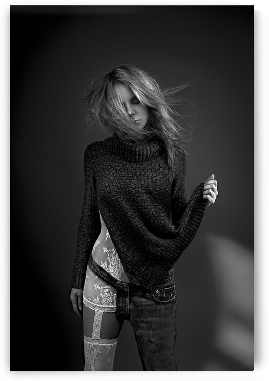 Black and white portrait of a blonde woman wearing both white lace lingerie and a wool sweater with a one-legged jean her hair floating in the wind by Artmood Visualz