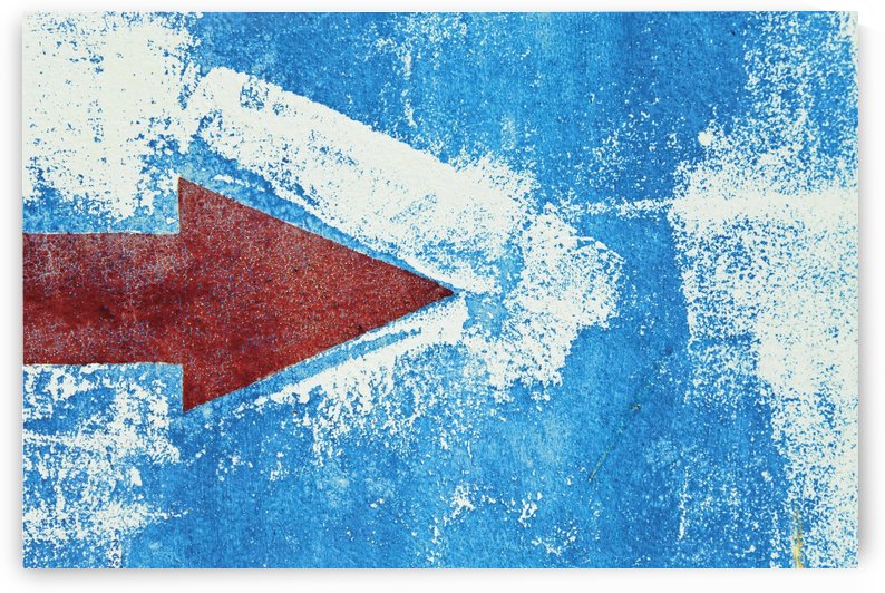 Red Arrow Painted On Blue Wall by PacificStock