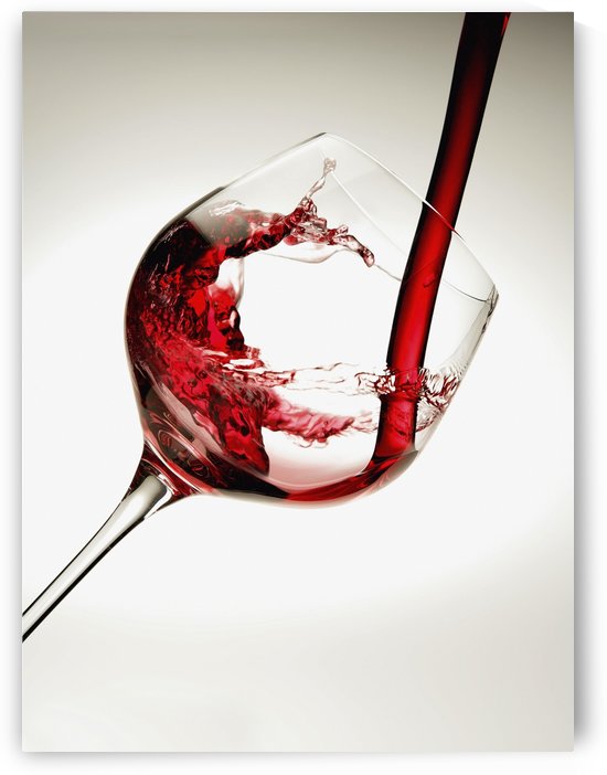 Red wine pouring into a glass by PacificStock