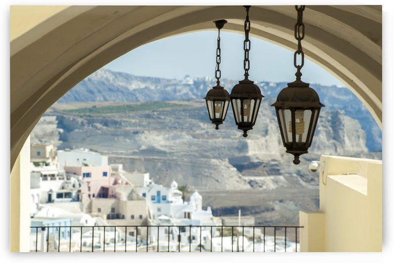 Lights hang from an arched ceiling with a view of a church, whitewashed buildings and landscape; Fira, Santorini, Greece by PacificStock