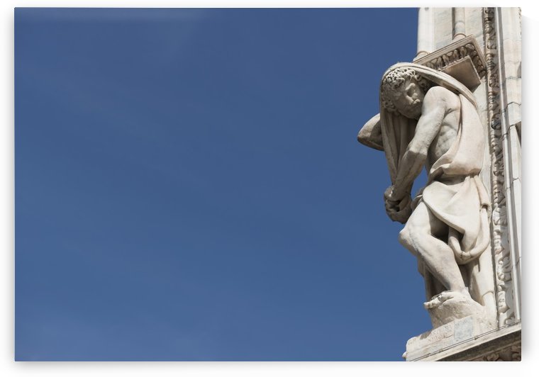 Carved sculpture of male likeness on the facade of Milan Cathedral against a blue sky; Milan, Lombardy, Italy by PacificStock