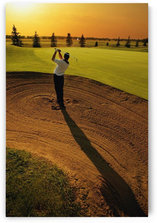 Golfer Taking A Swing From A Golf Bunker by PacificStock