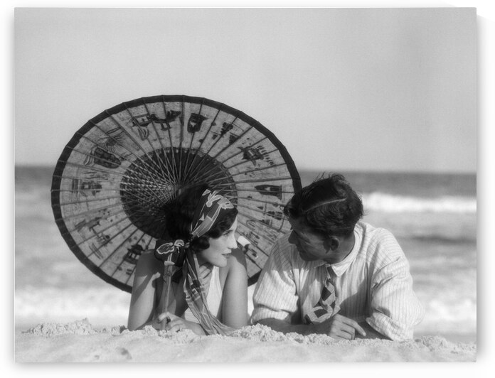 1920s COUPLE LAYING UNDER ORIENTAL PARASOL BEACH 195601 by Panoramic Images