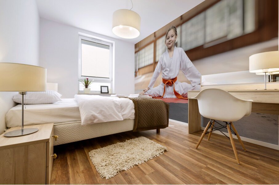 Young girl practicing karate split in dojo Mural print