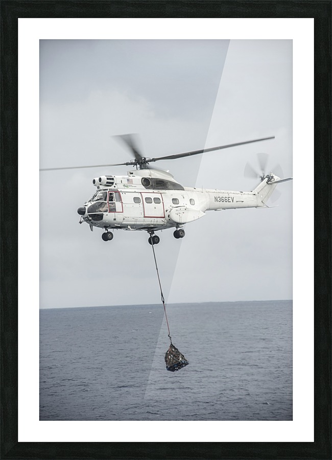 An SA-330 Puma transport helicopter moves cargo during a vertical