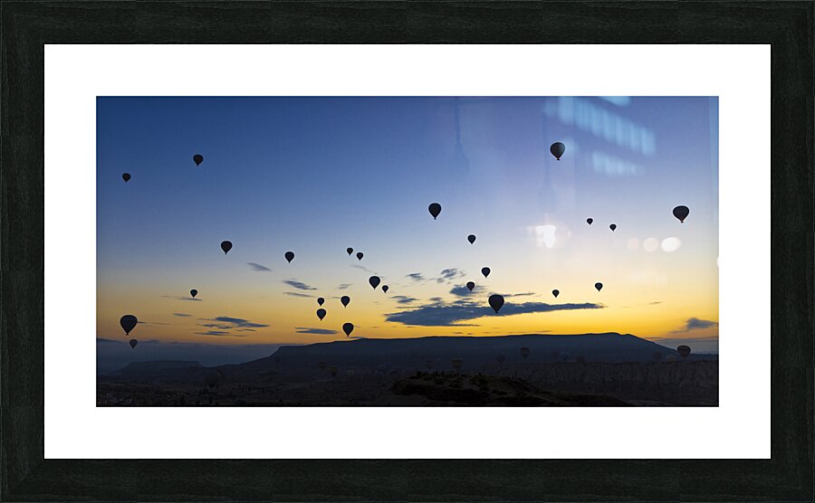 hot air balloons take off at sunrise over the city of goreme  Picture Frame print