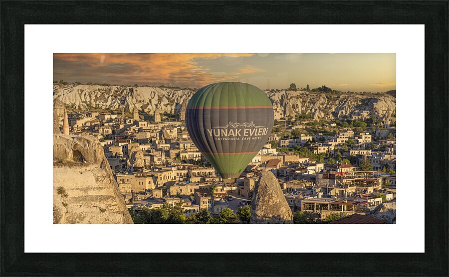 hot air balloon flies low over the city of goreme Picture Frame print