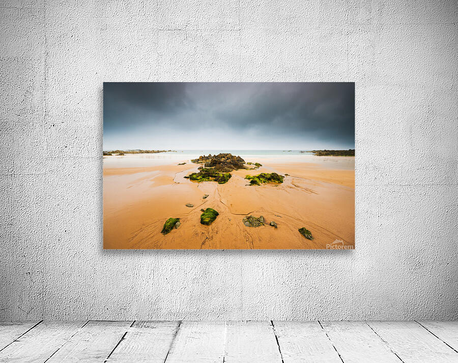 Empty beach with rocks and dark sky by Philippe Lejeanvre