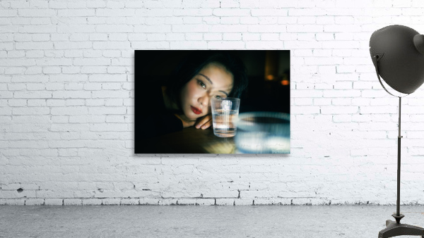 Young woman looking through a glass of water Wall Preview