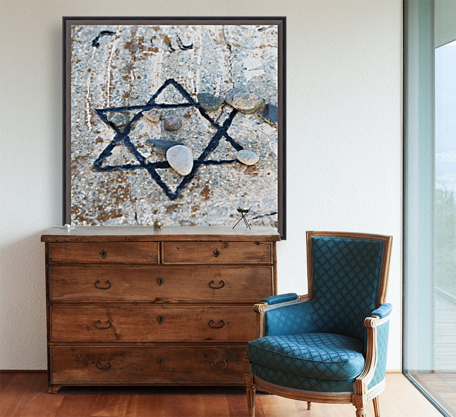 A star of david etched and painted on a rock with stones laying on it Reproduction
