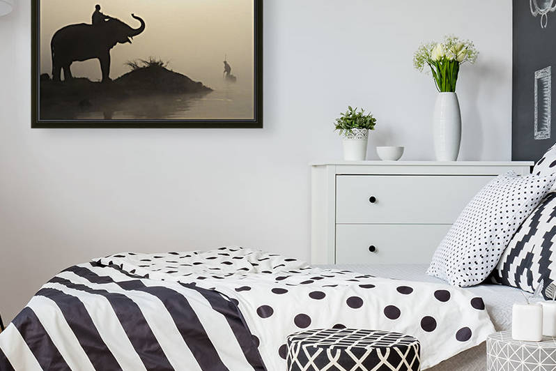 An Elephant With Its Mahout Stand At The Edge Of The Rapti River Near Sauraha And Chitwan National Park As A Man Pushes His Dugout Canoe Along The River; Nepal by PacificStock