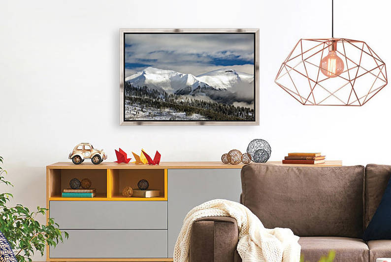 Snow covered mountain with frosted evergreen trees on hillside with clouds in the valley and blue sky; Radium Hot Springs, British Columbia, Canada by PacificStock