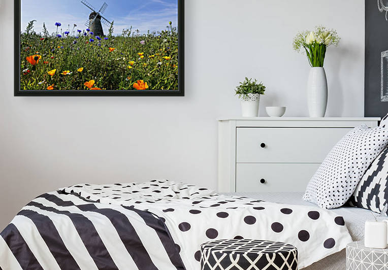 A windmill against a blue sky and cloud with a field of wildflowers in the foreground; Whitburn, Tyne and Wear, England by PacificStock