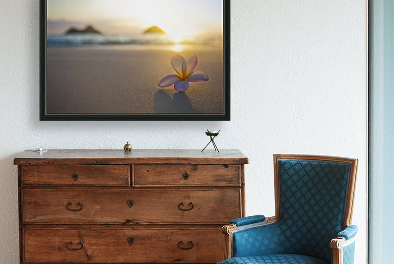 A pink plumeria flower sits on the sand of Lanikai Beach in Kailua with a view of Mokulua twin islands and the ocean at sunset in the distance; Kailua, Oahu, Hawaii, United States of America by PacificStock