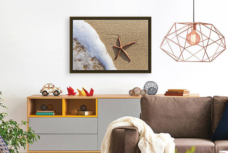 A red live Finger Starfish, also known as Linckia Sea Star, found along a sandy beach with white ocean tide washing up; Honolulu, Oahu, Hawaii, United States of America by PacificStock