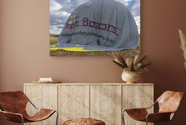 men deflate a hot air balloon at the end of a sightseeing tour by Gualtiero Boffi