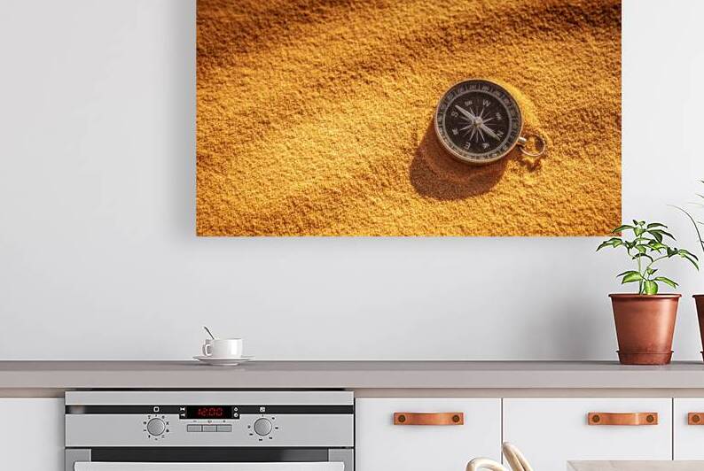 metal compass on sand by Gualtiero Boffi
