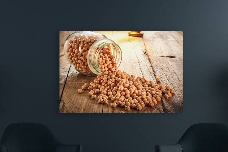 A glass jar filled with chickpeas which is tipped by IonelGherman