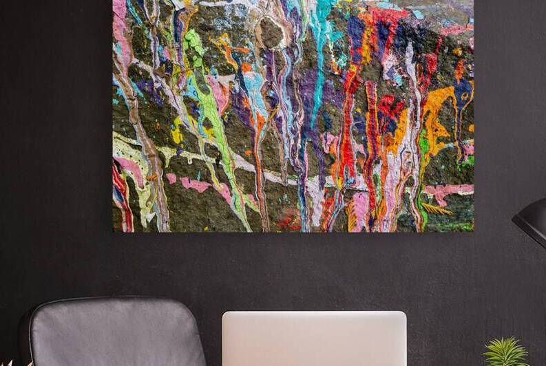 Many colors of paint spilled on a rock by David Reinhold