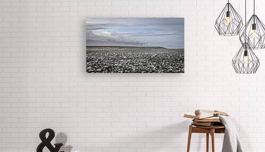 Electricity pylons crossing a desolate rocky plain in iceland by Gualtiero Boffi
